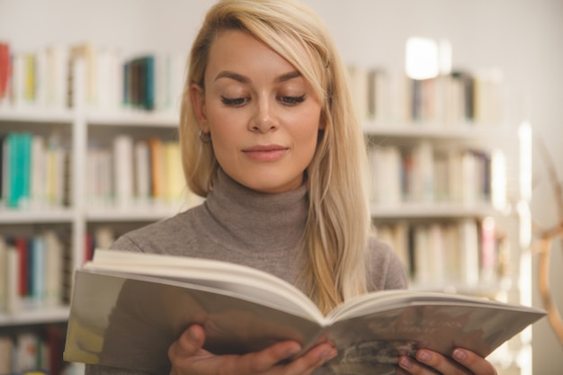 Schönheit, die im Geschäft für Bücher kauft