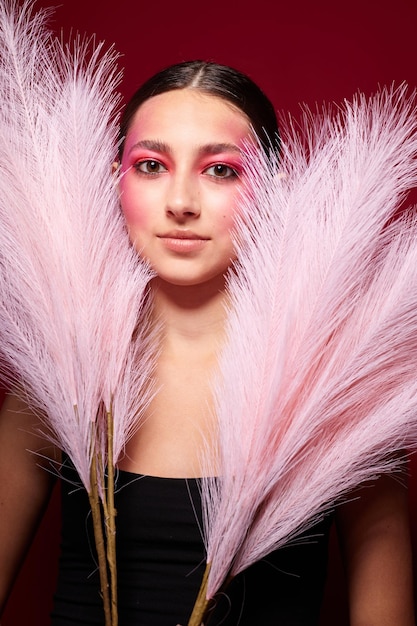 Schönheit Mode weibliche rosa Federn rosa Gesicht Make-up posiert attraktiv aussehen rosa Hintergrund unverändert