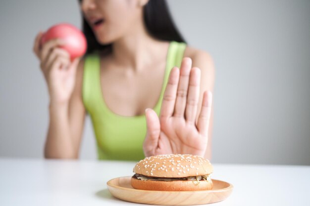 Foto schönheit schlanker weiblicher körper verwirrt hamburger frau im restaurant erreicht gewichtsverlustziel für ein gesundes leben verrückt nach schlankheit dünne taille ernährungsberaterin diät-körperform