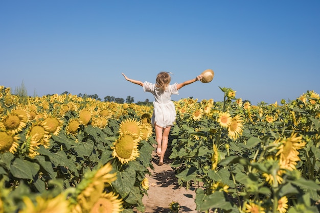 Schönheit sonnenbeschienene Frau auf gelbem Sonnenblumenfeld Freiheits- und Glückskonzept Glückliches Mädchen im Freien