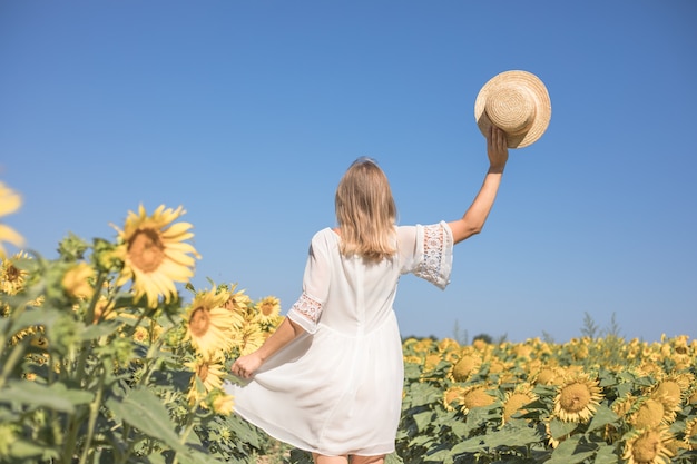 Schönheit sonnenbeschienene Frau auf gelbem Sonnenblumenfeld Freiheits- und Glückskonzept Glückliches Mädchen im Freien