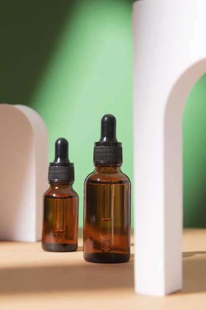 Schönheits-Kollagen-Gesichtsserum in einer Glastropfflasche im Bogen auf grünem Hintergrund Trendiger Schuss von Kosmetikverpackungen Ätherisches Öl mit natürlichen Inhaltsstoffen