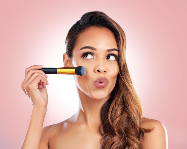 Schönheits-Make-up und Gesicht von Frau mit Pinsel auf rosa Hintergrund für Salon Wellness und Luxus Kosmetologie Ästhetik und weibliche Person mit Werkzeugen für Foundation Kosmetik und Glamour im Studio