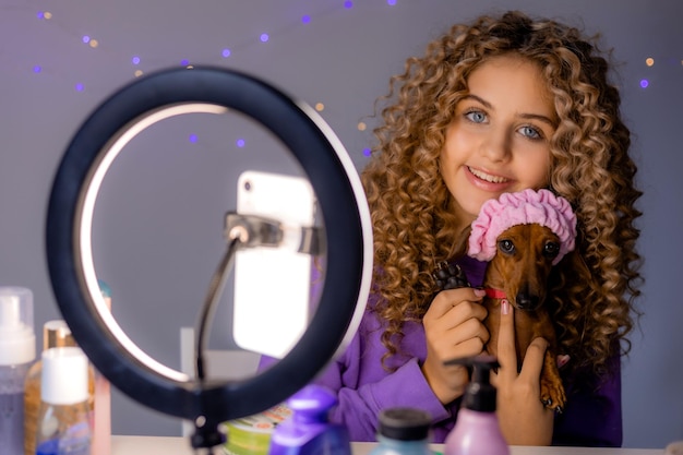 Schönheitsbloggerin mit Hund leitet eine Live-Sendung, kommuniziert mit Abonnenten und beantwortet Fragen