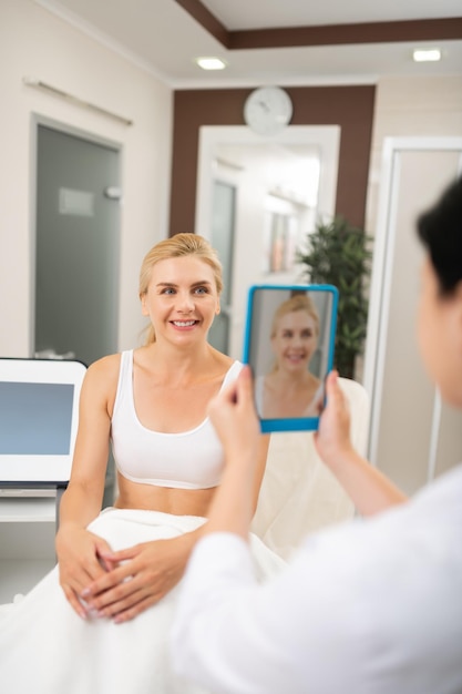 Foto schönheitsdoktor, der ein foto ihrer patientin macht