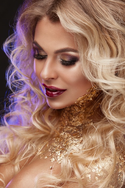 Schönheitsfrau, blondes Haar, professionelles Make-up, goldene Farbe.