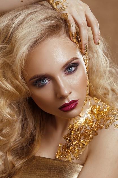 Schönheitsfrau, blondes haar, professionelles make-up, goldene farbe.