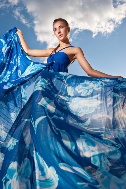 Schönheitsfrau im blauen Kleid auf der Wüste