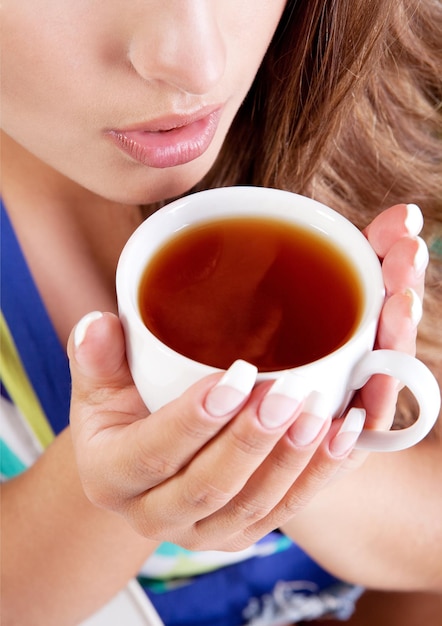 Schönheitsfrau mit frischer Tasse schwarzem Tee