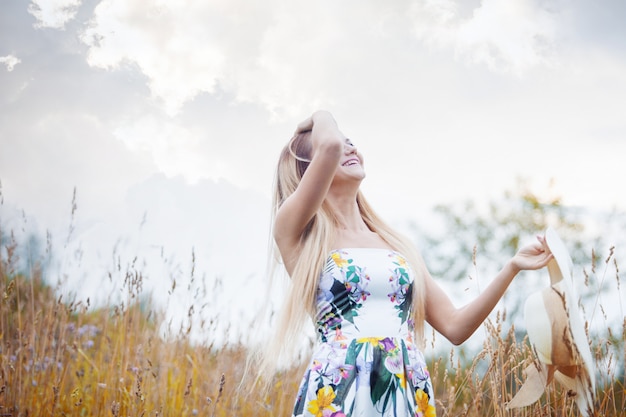 Schönheitsfrauen in einem Strohhut allein mit Natur