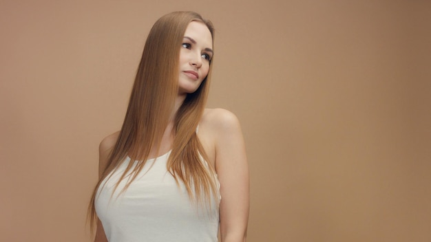 Schönheitsfrauenmodell im Studio auf beigem Hintergrund mit Wind im Haar, das es weiße Spitze durchbrennt