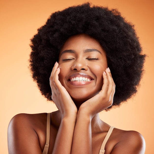 Schönheitsgesicht und Hautpflege mit einer vorbildlichen schwarzen Frau im Studio auf einem orangefarbenen Hintergrund mit einem freudigen oder sorglosen Ausdruck Kosmetik Haut und Gesundheit mit einer glücklichen jungen Frau, die für Wellness posiert