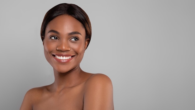 Schönheitskonzeptporträt der jungen nackten schönen schwarzen Frau, die beiseite schaut