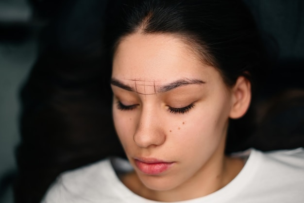 Schönheitsmeisterhände machen permanentes Augenbrauen-Make-up Minimales Hauttrauma Augenbrauen-Microblading wird mit Manipulatorgriff und spezieller Düse mit Nadeln durchgeführt Geschicklichkeitsstufe des Kosmetikers