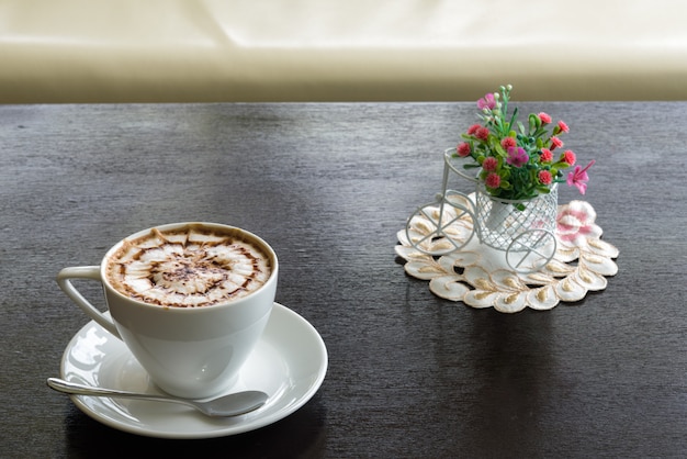 Schönheitsmuster auf Spitzenkaffee und ein Cupkuchen