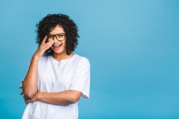 Schönheitsnahaufnahmeporträt des jungen Afroamerikanermädchens mit Afro-Haaren. Mädchen, das Kamera betrachtet. Isoliert über blauem Hintergrund.