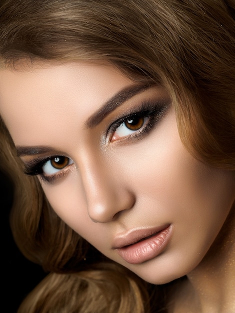 Schönheitsporträt der jungen Frau mit goldenem Make-up. Perfektes Haut- und Mode-Make-up, rauchige Augen. Sinnlichkeit, Leidenschaft, trendiges luxuriöses Make-up-Konzept.