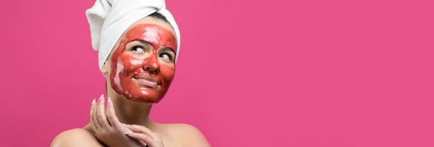 Schönheitsporträt einer Frau in weißem Handtuch auf dem Kopf mit goldener Pflegemaske im Gesicht Hautpflege-Reinigung Öko-Bio-Kosmetik-Spa-Relax-Konzept