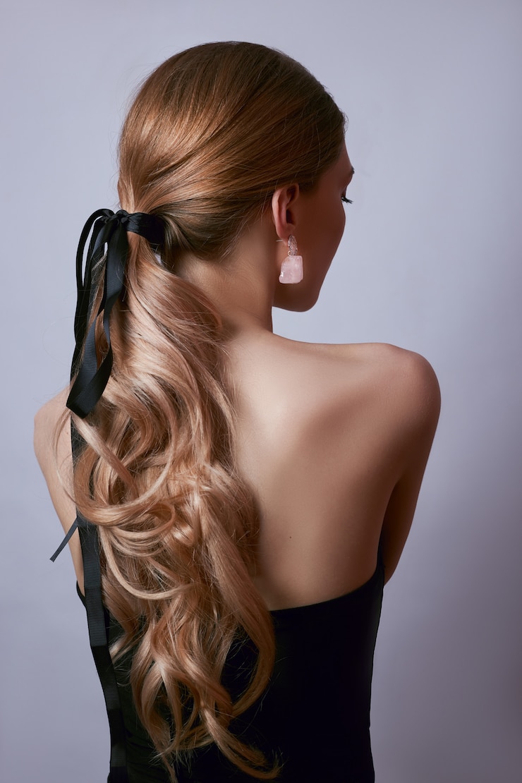 Foto schönheitsporträt einer frau mit langen haaren, ohrringen in ihren ohren und teurem schmuck an ihren händen