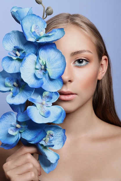 Schönheitsporträt eines Mädchens mit perfektem Make-up auf ihrem Gesicht, farbigem Lidschatten, langen schönen Haaren