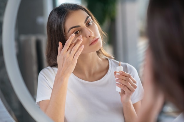 Schönheitsroutine. Eine Frau, die einen Concealer auf ihre Haut aufträgt