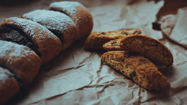 Schokobrötchen mit leckerer Füllung und leckeren Crackern, bestreut mit Puderzucker. Vor dem Hintergrund von braunem Kraftpapier