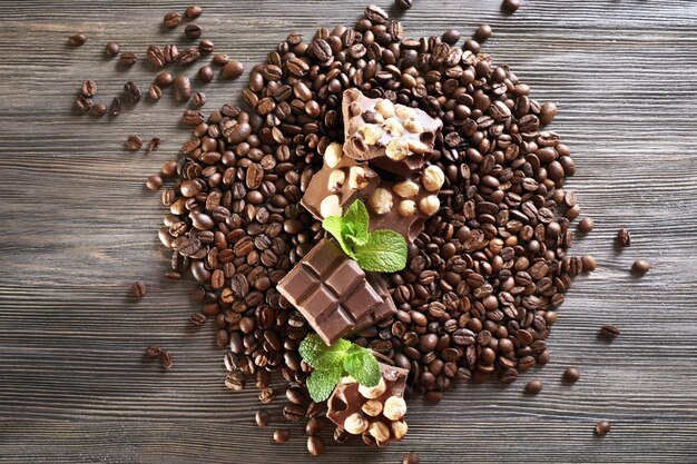 Schokolade mit Minze und Kaffeebohnen auf Holztisch