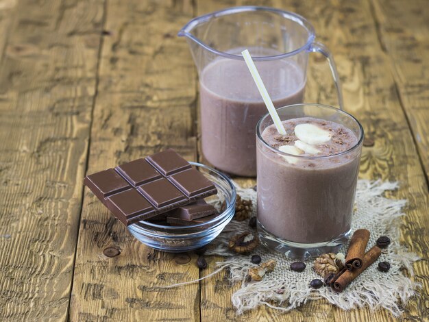 Schokolade und Schokoladenbanane Smoothie mit Zimt auf einer rustikalen Tabelle.