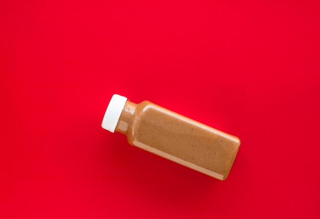 Schokoladen-Bananen-Smoothie-Flasche auf rotem Flatlay