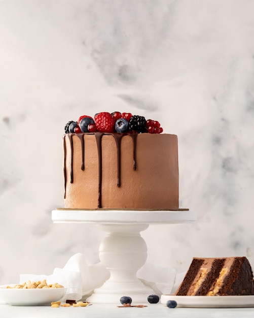 Schokoladen-Beeren-Kuchen-Beeren-Biskuit mit frischen Beeren und Sauerrahm auf weißem Hintergrund