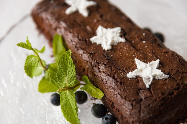 Schokoladen-Brownie-Kuchen mit frischen Blaubeeren und weißen Zuckersternen.