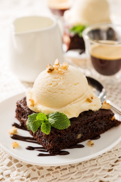 Foto schokoladen-brownie mit vanilleeis, nüssen und minze