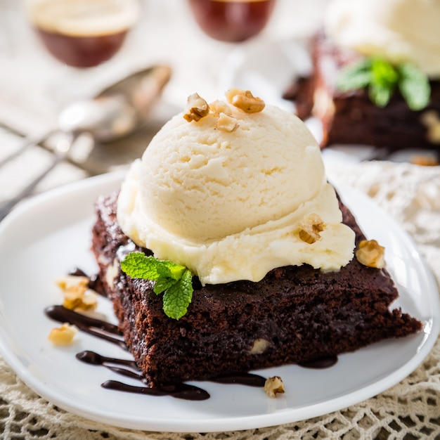 Foto schokoladen-brownie mit vanilleeis, nüssen und minze