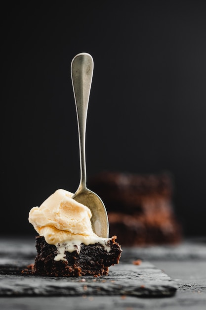 Foto schokoladen-brownie und vanilleeis auf schwarzem schieferstein