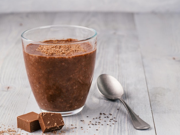 Schokoladen-Chia-Pudding in einem Glas auf einem grauen Tisch