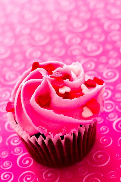 Schokoladen-Cupcake mit rosa Zuckerguss zum Valentinstag dekoriert.