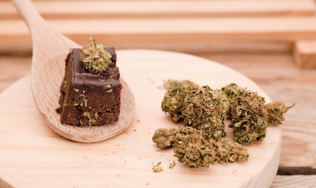 Schokoladen-Cupcake-Muffins mit CannabisknospenMarihuana-Kuchen auf einem braunen Holztisch