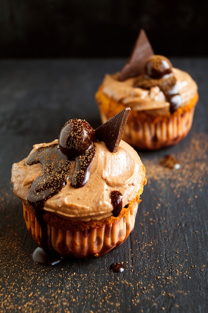 Schokoladen-Cupcakes mit einer Kirsche. ein dunkles Foto.