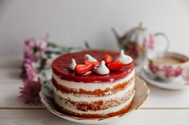 Schokoladen-Erdbeer-Joghurt-Kuchen mit frischen Früchten auf Holztisch dekoriert Köstlicher und süßer rosa Erdbeerkuchen für Valentinstag oder Geburtstagsfeier Hausgemachtes Bäckereikonzept