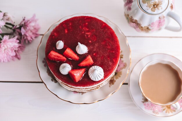 Schokoladen-Erdbeer-Joghurt-Kuchen mit frischen Früchten auf Holztisch dekoriert Köstlicher und süßer rosa Erdbeerkuchen für Valentinstag oder Geburtstagsfeier Hausgemachtes Bäckereikonzept