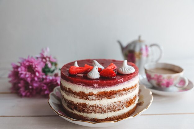 Schokoladen-Erdbeer-Joghurt-Kuchen mit frischen Früchten auf Holztisch dekoriert Köstlicher und süßer rosa Erdbeerkuchen für Valentinstag oder Geburtstagsfeier Hausgemachtes Bäckereikonzept