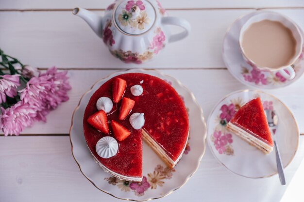 Schokoladen-Erdbeer-Joghurt-Kuchen mit frischen Früchten auf Holztisch dekoriert Köstlicher und süßer rosa Erdbeerkuchen für Valentinstag oder Geburtstagsfeier Hausgemachtes Bäckereikonzept