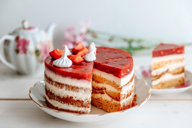 Schokoladen-Erdbeer-Joghurt-Kuchen mit frischen Früchten auf Holztisch dekoriert Köstlicher und süßer rosa Erdbeerkuchen für Valentinstag oder Geburtstagsfeier Hausgemachtes Bäckereikonzept