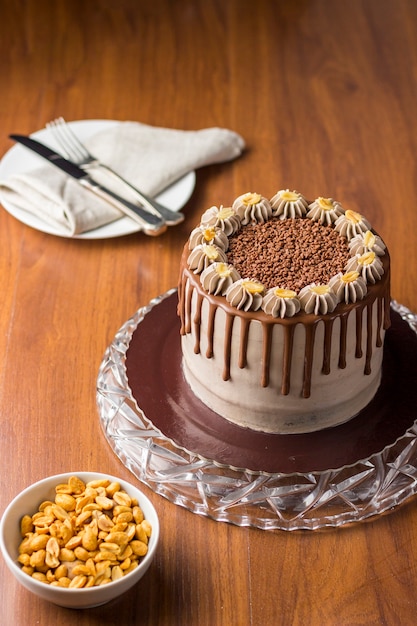 Schokoladen-Erdnuss-Kuchen. Kuchen aufladen. Auf hölzernem Hintergrund.