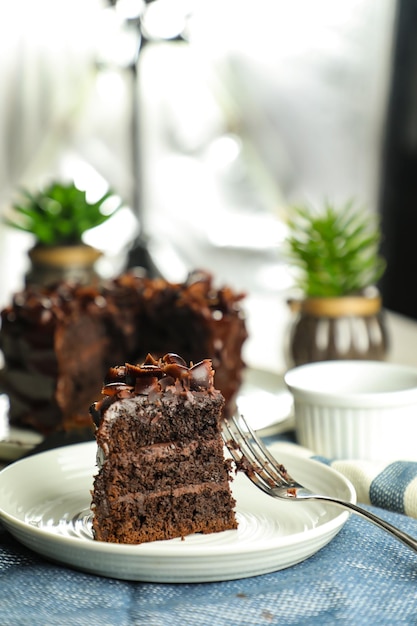 Schokoladen-Fudge-Kuchen mit Gabel und Messer, serviert auf einem Teller auf dem Essenstisch, Draufsicht, Café, Backdessert