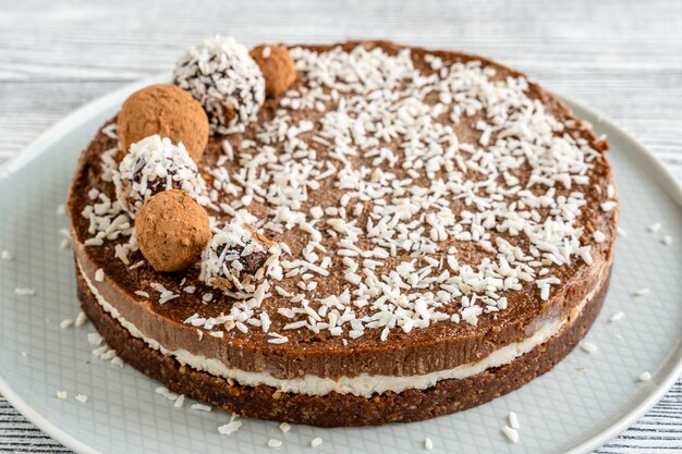 Schokoladen-Kokos-Kuchen auf einem weißen Holz.