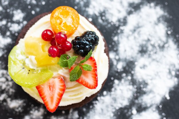 Schokoladen-Minikuchen mit Frischkäsefrüchten und Beeren Draufsicht Kopienraum Nahaufnahme