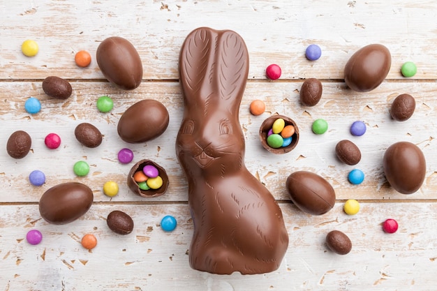 Schokoladen-Osterhaseneier und Süßigkeiten auf rustikalem Hintergrund