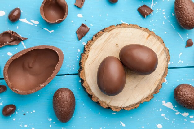 Schokoladen-Osterhaseneier und Süßigkeiten auf rustikalem Hintergrund