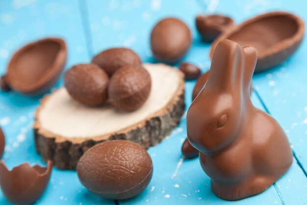 Schokoladen-Osterhaseneier und Süßigkeiten auf rustikalem Hintergrund